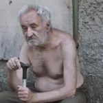 homem-idoso-triste-do-mendigo-com-um-bastão-que-senta-se-na-rua-da-pobreza-154329082