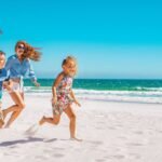 family-running-through-beach-1583517192